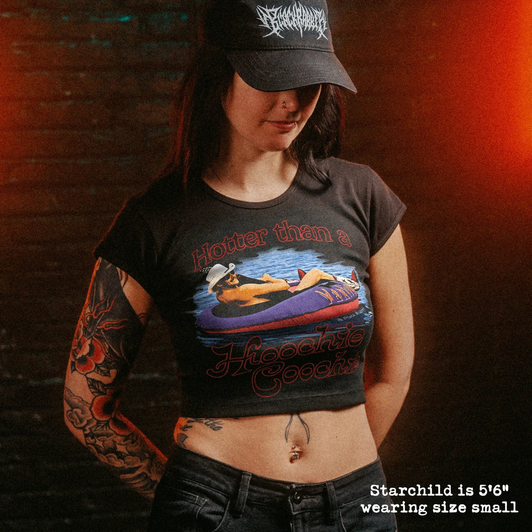 Female model wearing cropped baby tee with hotter than a hoochie coochie graphic
