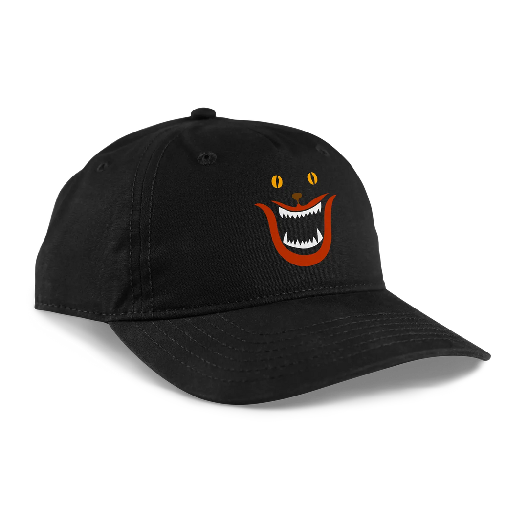 Black baseball cap featuring a cartoon cat face with orange eyes, an open mouth showing white teeth, and red accents on the cheeks.