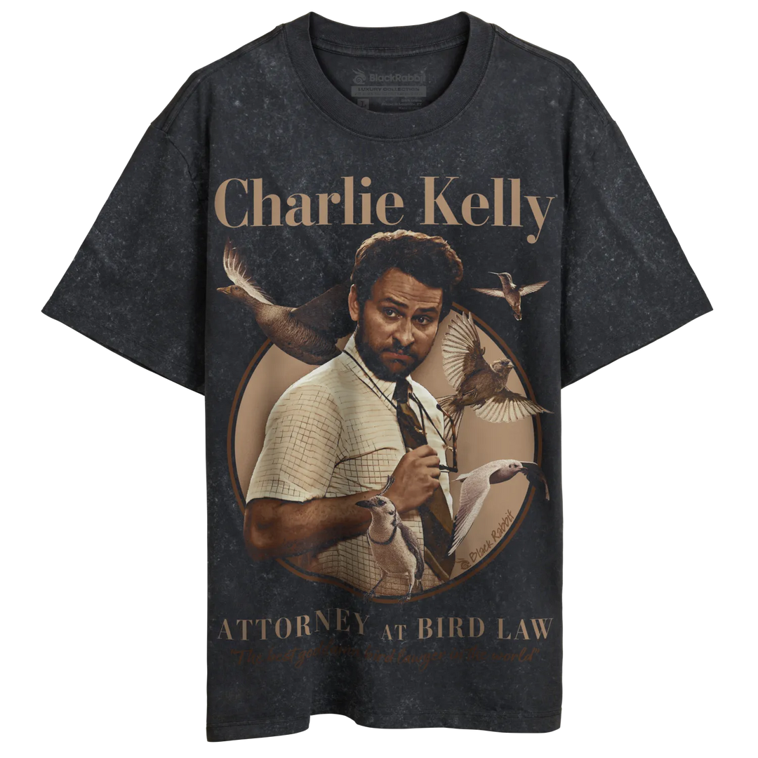 Charcoal gray t-shirt with graphic of charlie kelly from ’parks and recreation’ in a suit, surrounded by birds. 