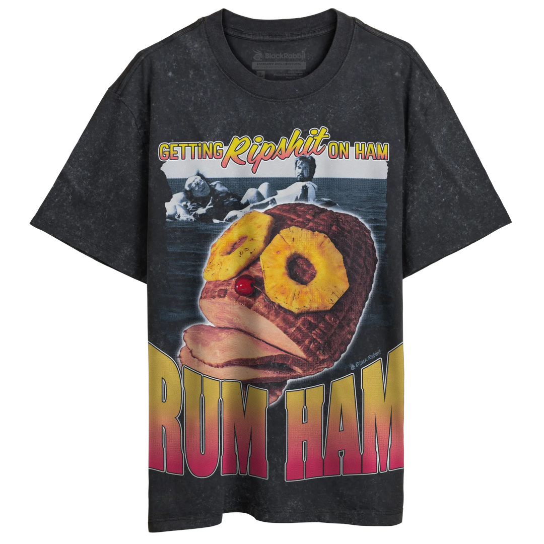 A dark gray t-shirt with a ’Rum Ham’ graphic featuring a glazed ham with pineapple rings for eyes, a cherry for a nose, and the phrase ’Getting Ripshit On Ham.’