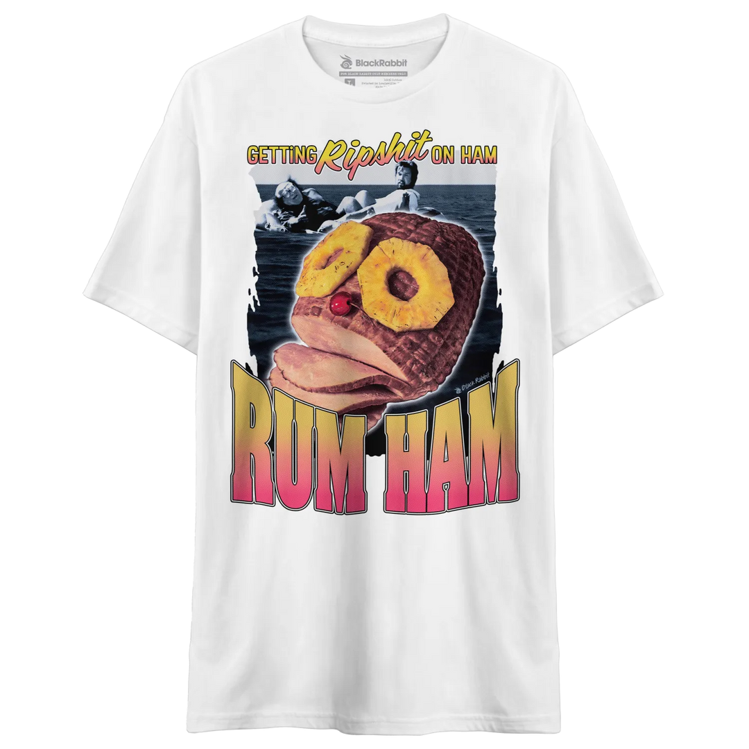 White short-sleeve t-shirt with a graphic print featuring a ham with pineapple slices as eyes and the words ’GETTING RIPSHIT ON HAM’ and ’RUM HAM.’