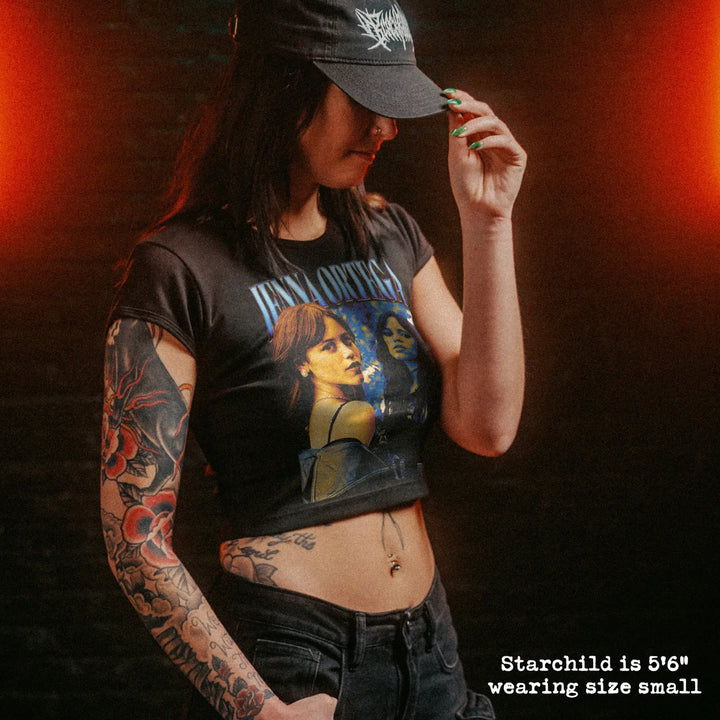 Female model wearing cropped baby tee with jenna ortega graphic
