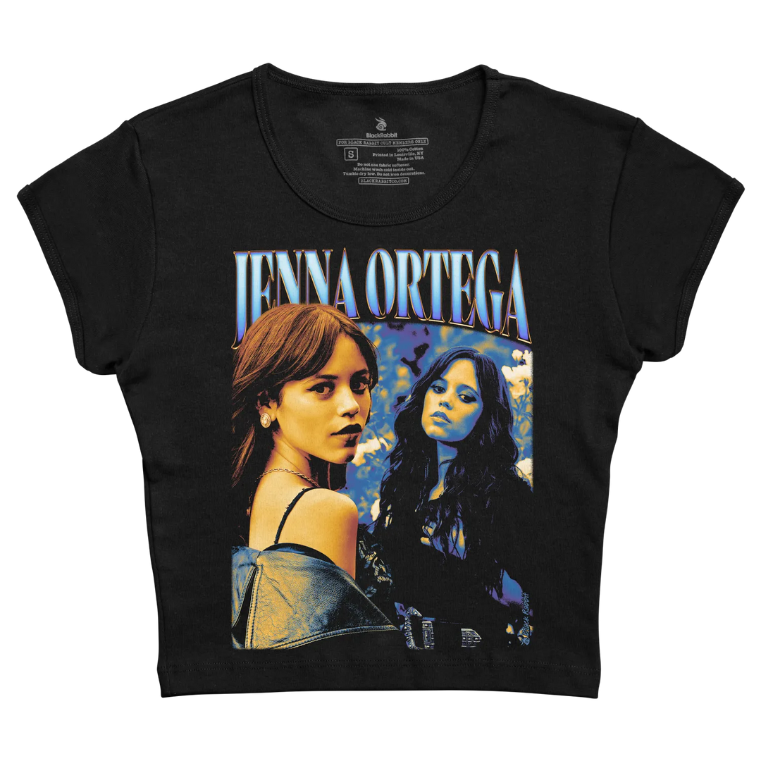 Black short-sleeved t-shirt featuring a vibrant graphic of jenna ortega with stylized blue and white lettering above her image. 