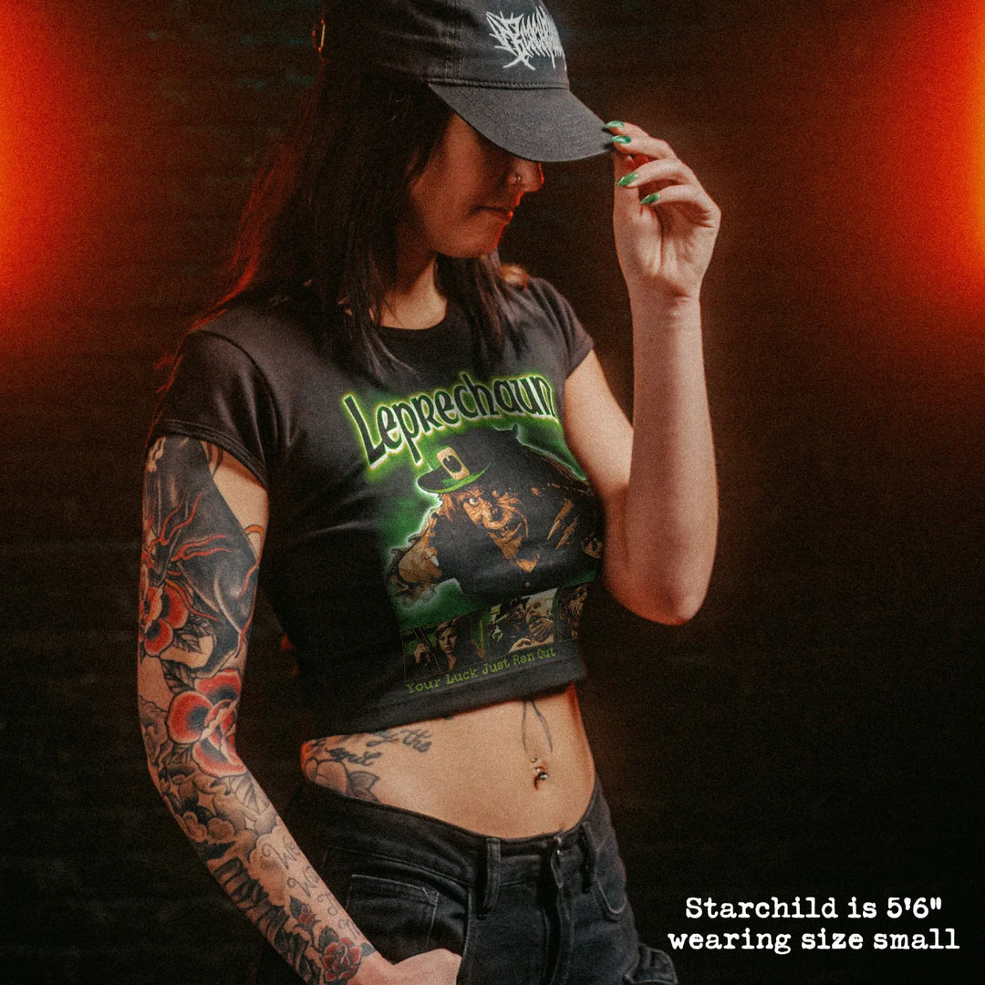 Female model wearing cropped baby tee with leprechaun graphic
