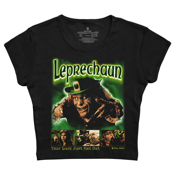 Black women’s t-shirt featuring a glowing green ’leprechaun’ graphic with the movie character in a leprechaun hat and claws, below which are three smaller scene panels from the film. 