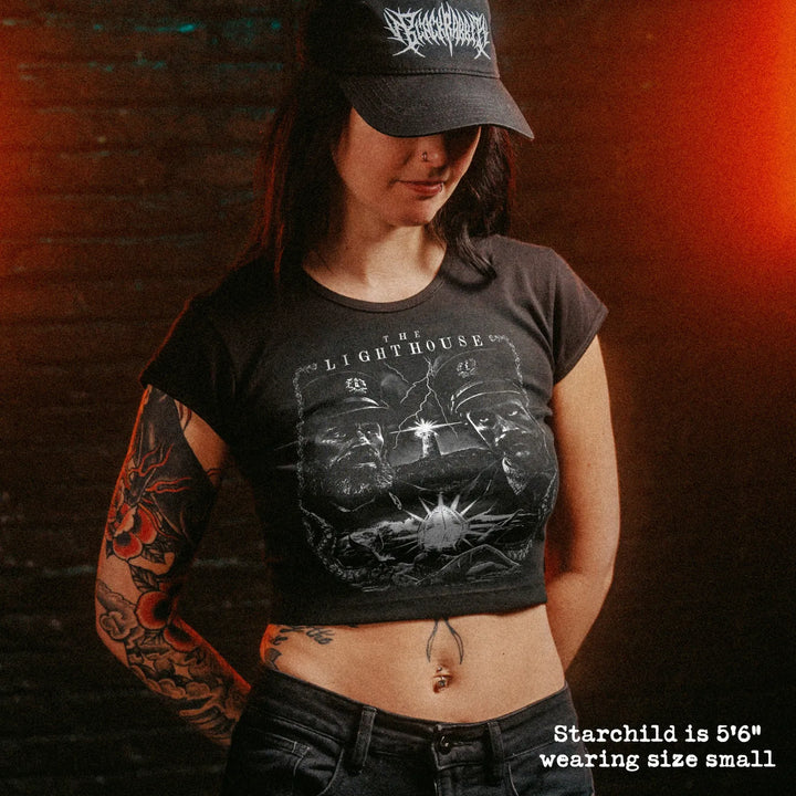 Female model wearing cropped baby tee with lighthouse graphic
