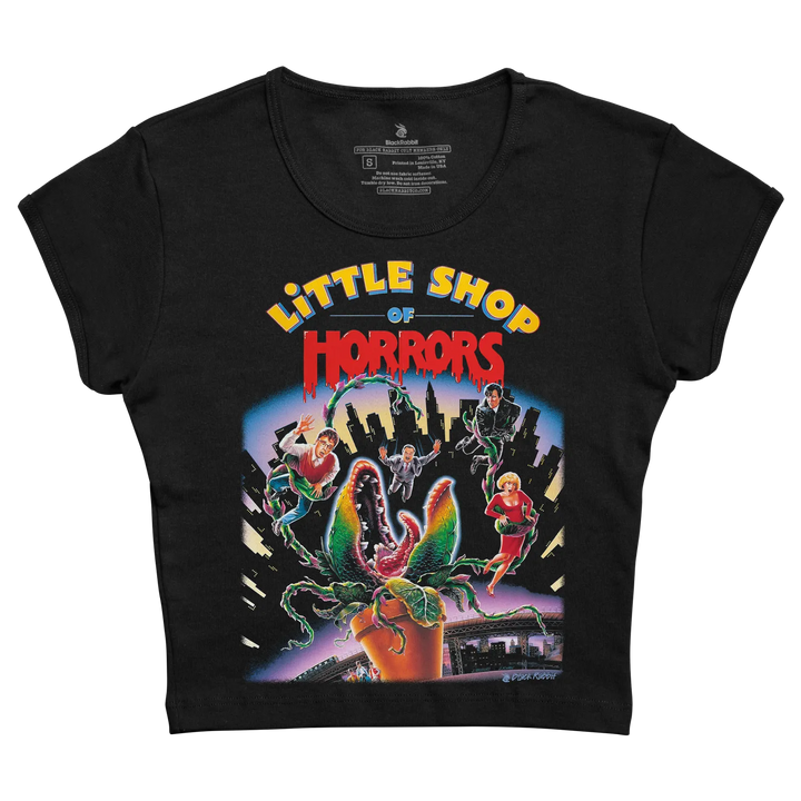 Black short-sleeved t-shirt featuring a vibrant, colorful graphic of the ’little shop of horrors’ movie poster with characters and the iconic plant. 