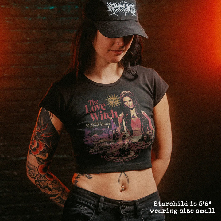 Female model wearing cropped baby tee with love witch graphic
