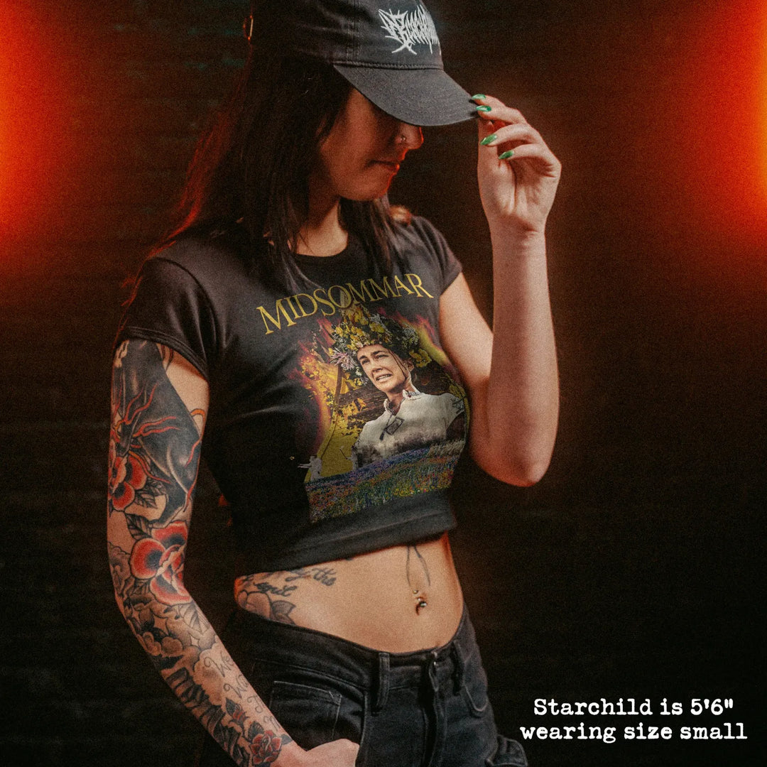 Female model wearing cropped baby tee with midsommar graphic
