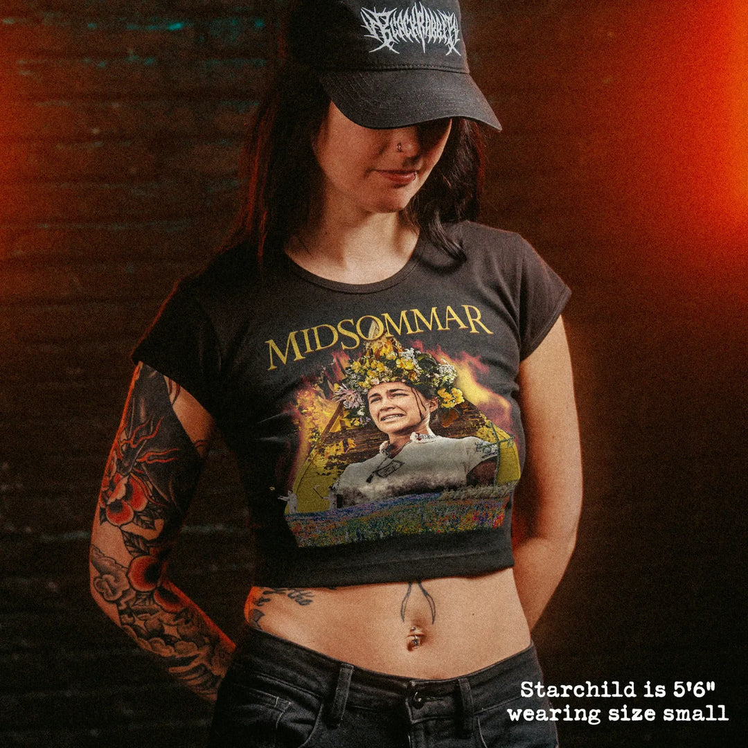 Female model wearing cropped baby tee with midsommar graphic
