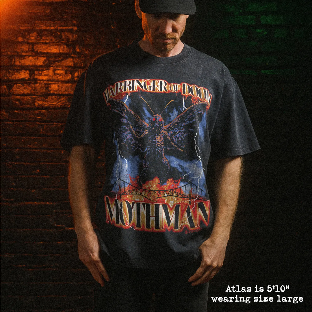 Male model wearing heavy stone washed tee with mothman graphic. 