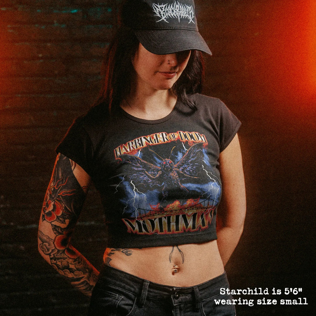 Female model wearing cropped baby tee with mothman graphic
