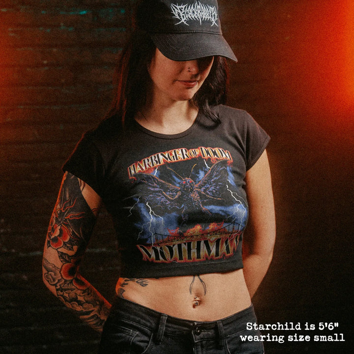 Female model wearing cropped baby tee with mothman graphic
