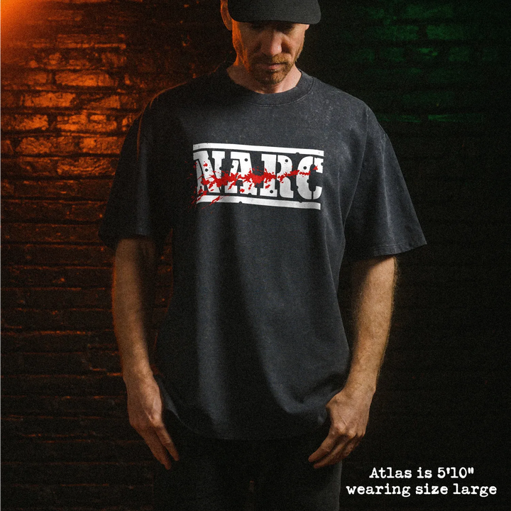 Male model wearing heavy stone washed tee with NARC graphic. 
