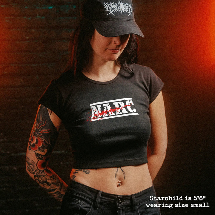 Female model wearing cropped baby tee with NARC graphic
