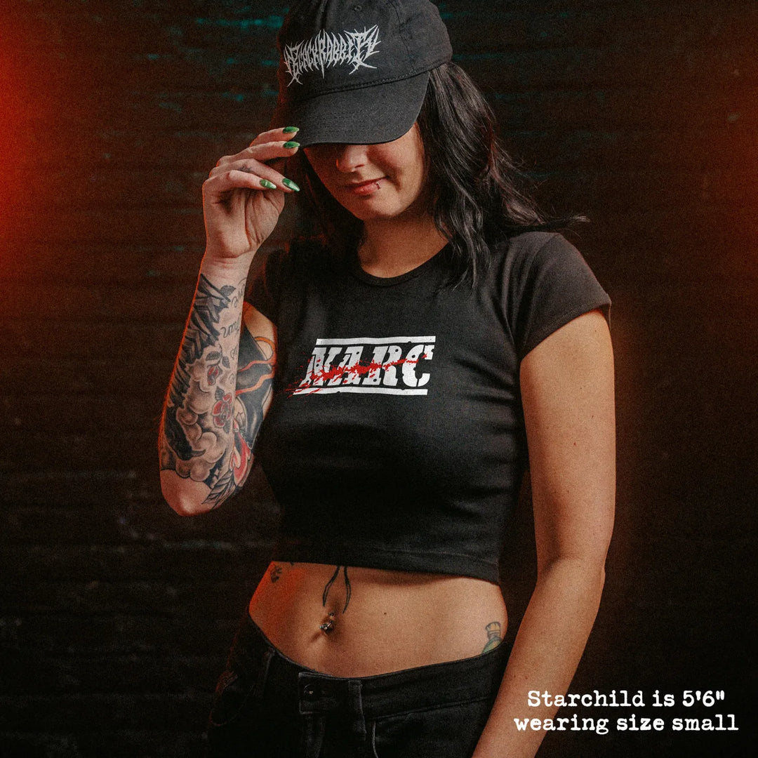 Female model wearing cropped baby tee with NARC graphic

