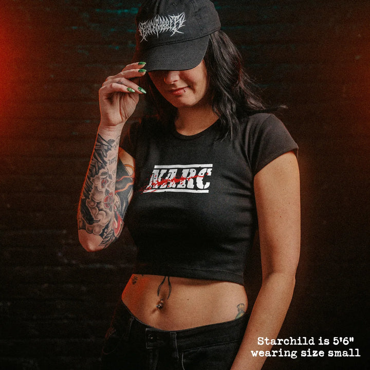 Female model wearing cropped baby tee with NARC graphic
