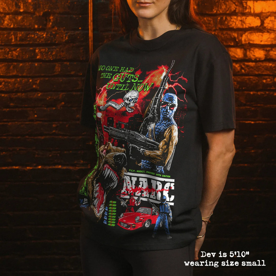 Female model wearing Black Rabbit Oversized Luxury Heavy Tee in Faded Black with NARC print. She is 5'10" and wearing a size small.