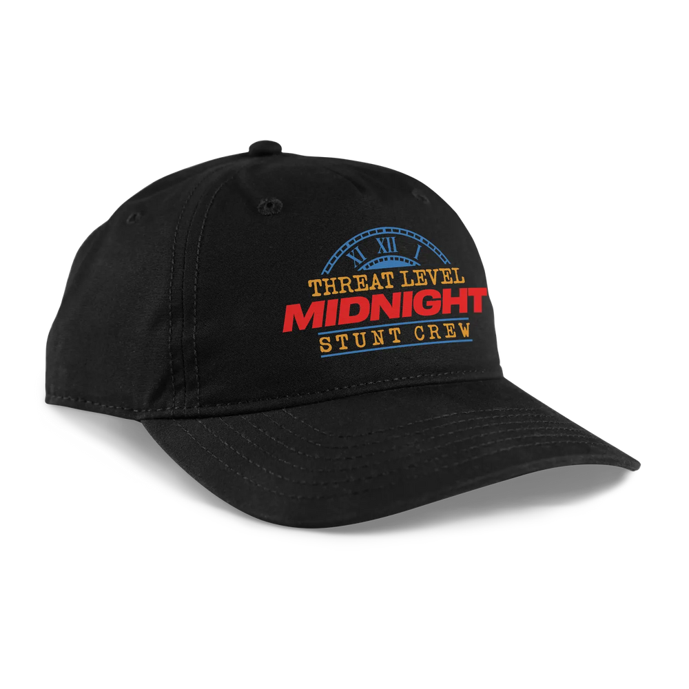 Black baseball cap featuring a bold ’threat level midnight stunt crew’ logo with red and blue lettering.