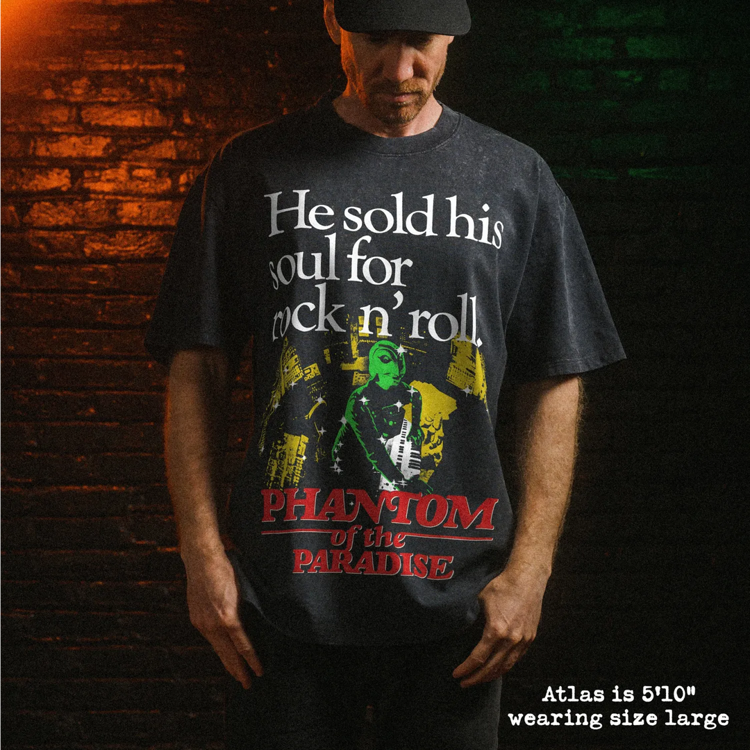 Male model wearing heavy stone washed tee with phantom of the paradise graphic. 