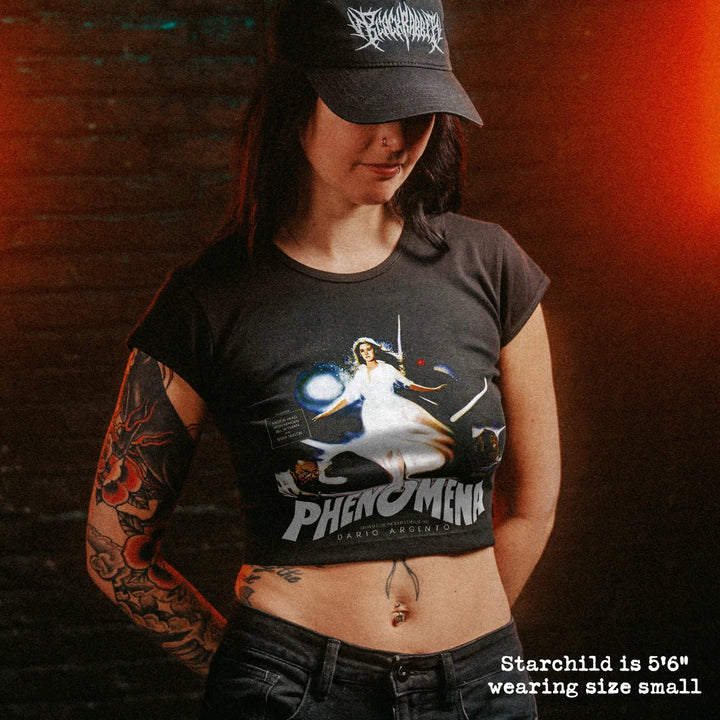 Female model wearing cropped baby tee with phenomena graphic
