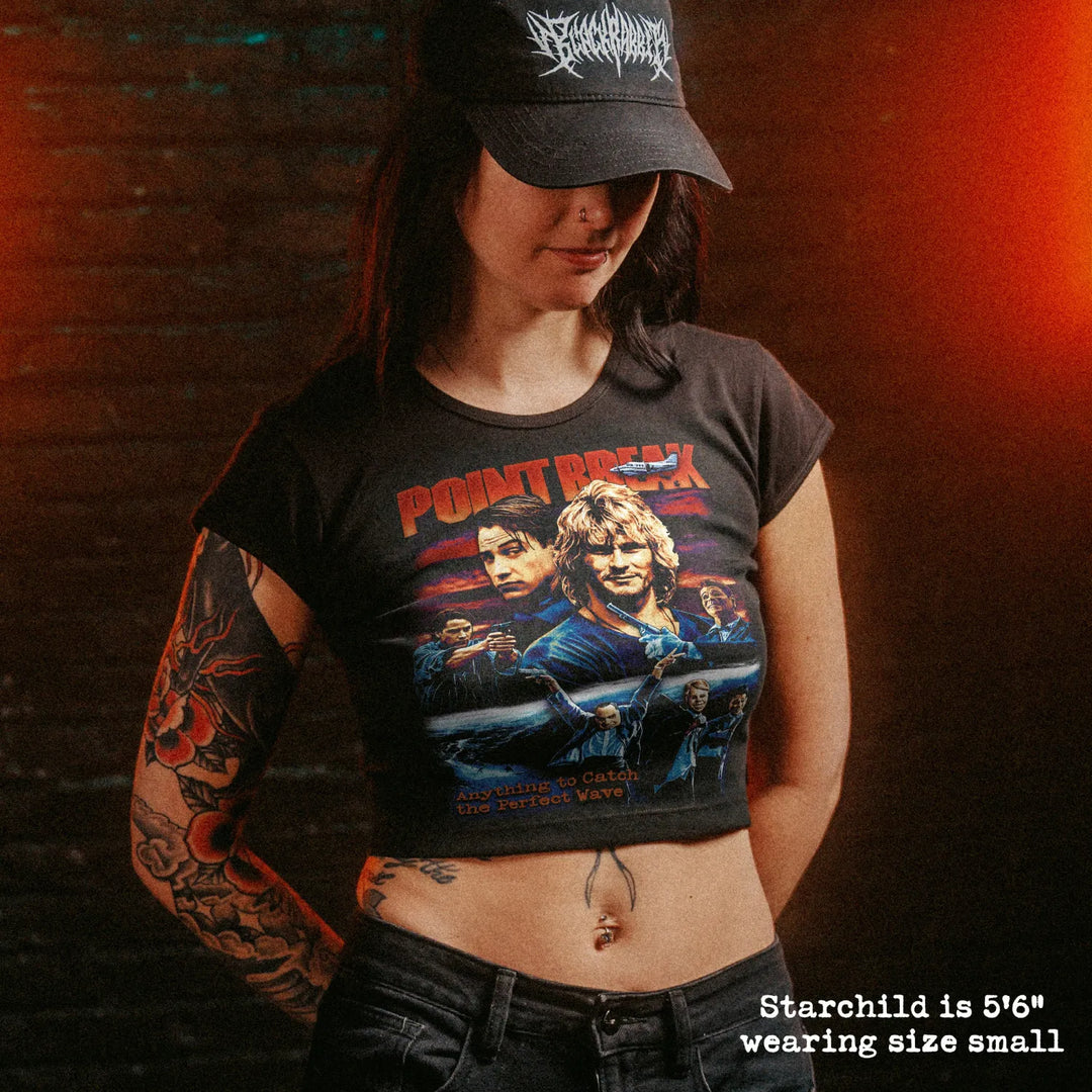 Female model wearing cropped baby tee with point break graphic
