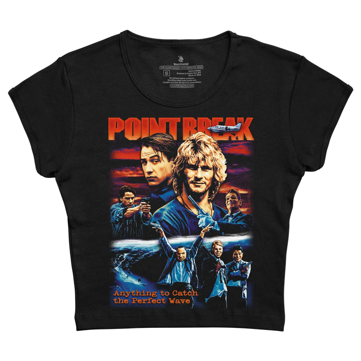 Black short-sleeved t-shirt featuring a vibrant graphic of the movie ’point break’ with orange and blue tones, depicting characters against a sunset ocean backdrop.