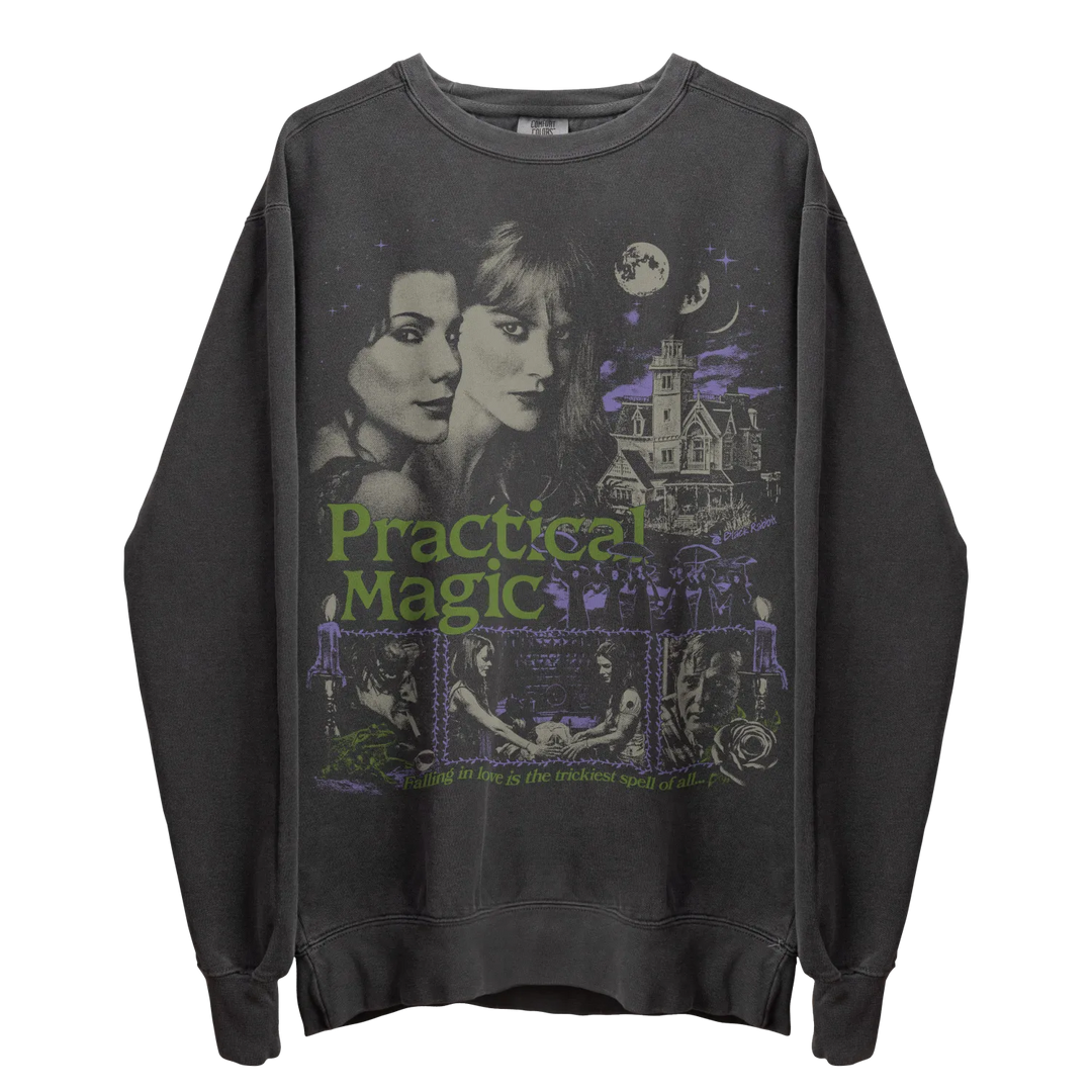 Dark gray long-sleeve sweatshirt with a graphic print featuring two women, a spooky house, and the words ’Practical Magic.’