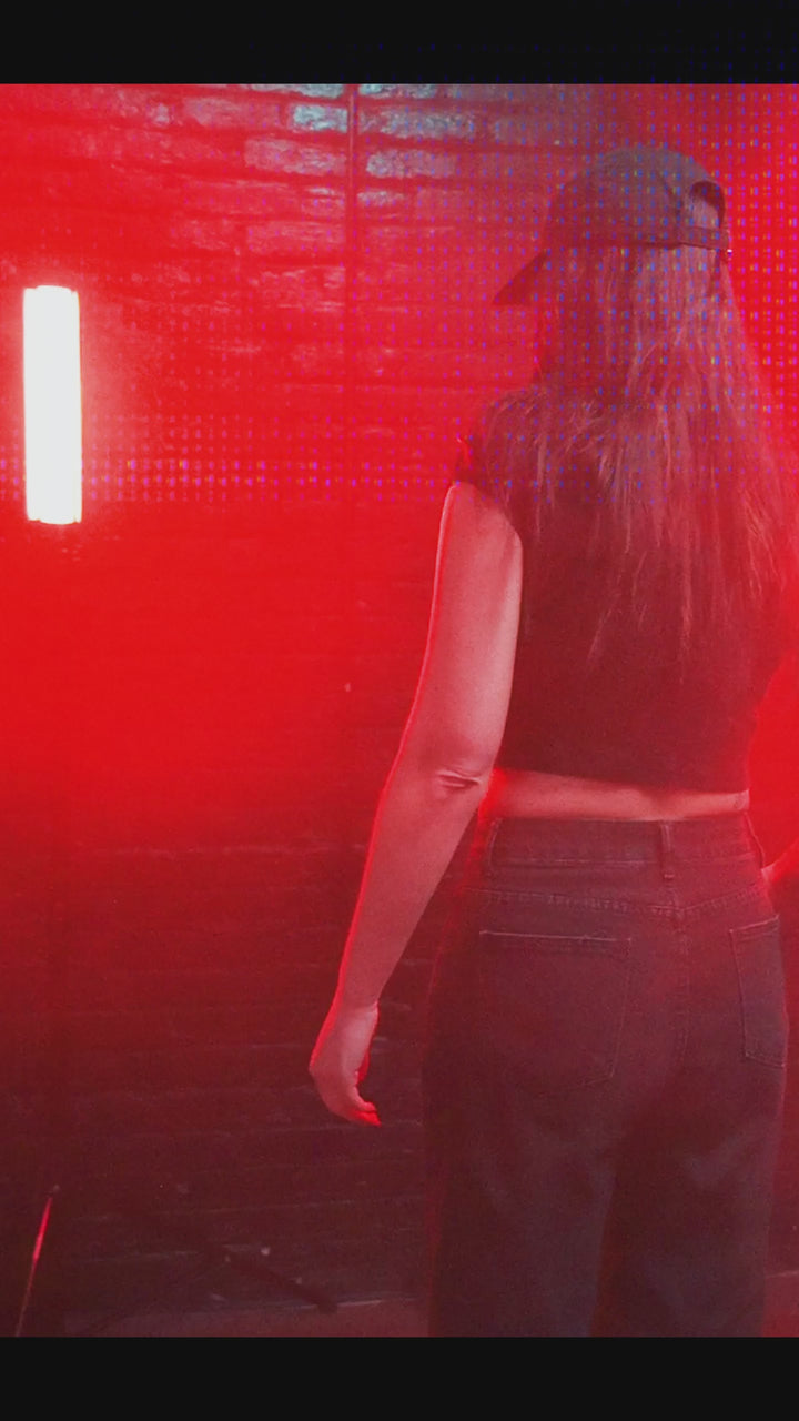 Female model wearing cropped baby tee with black rabbit death metal graphic
