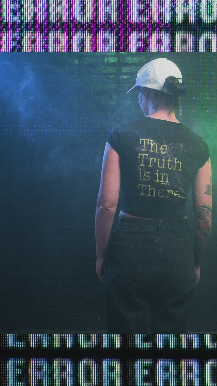 Female model wearing cropped baby tee with area 51 graphic
