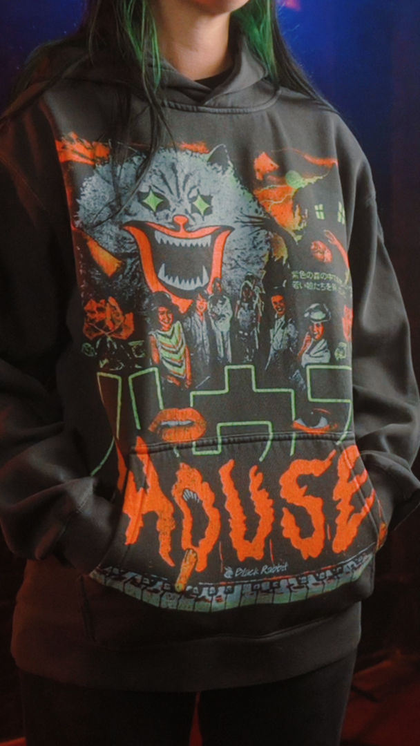 Black hoodie with ’house’ graphic design featuring a cat and haunted house illustration. 