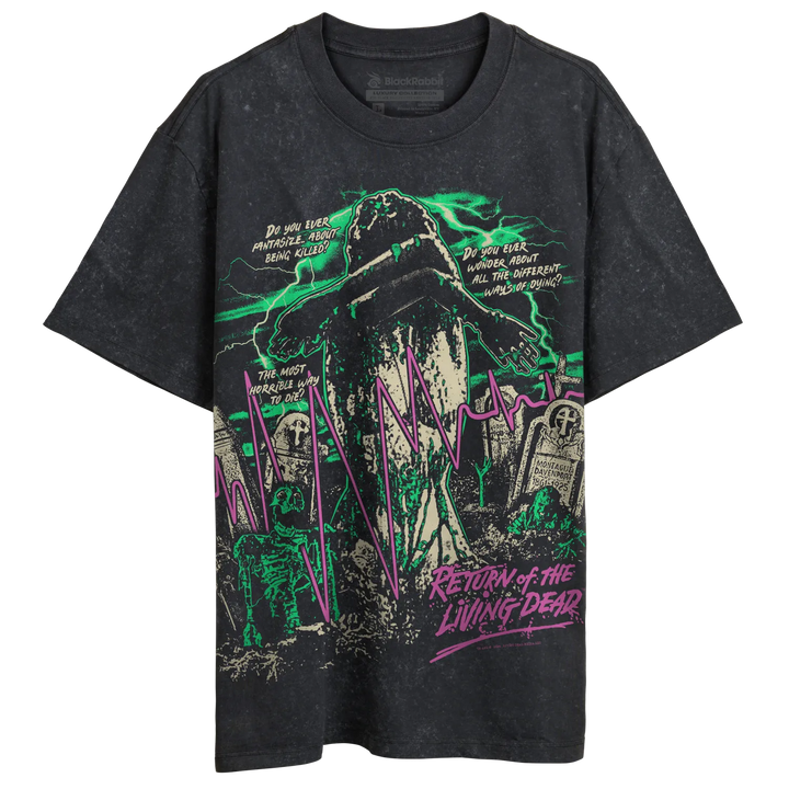 A black stone-wash graphic t-shirt featuring a horror-themed graveyard scene with green and pink details, displayed flat against a white background.