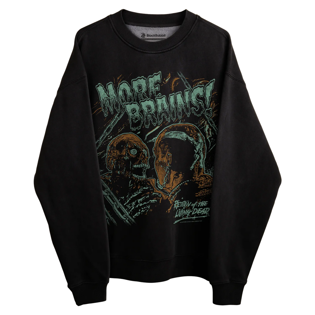 Black crewneck sweatshirt with graphic design of zombie heads and the text ’more brains’ in green, orange, white, and blue.