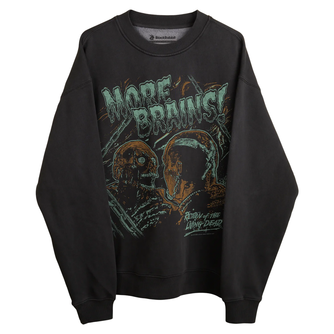 Black long-sleeved sweatshirt with ’more brains’ graphic and zombie design, featuring black scale brand.