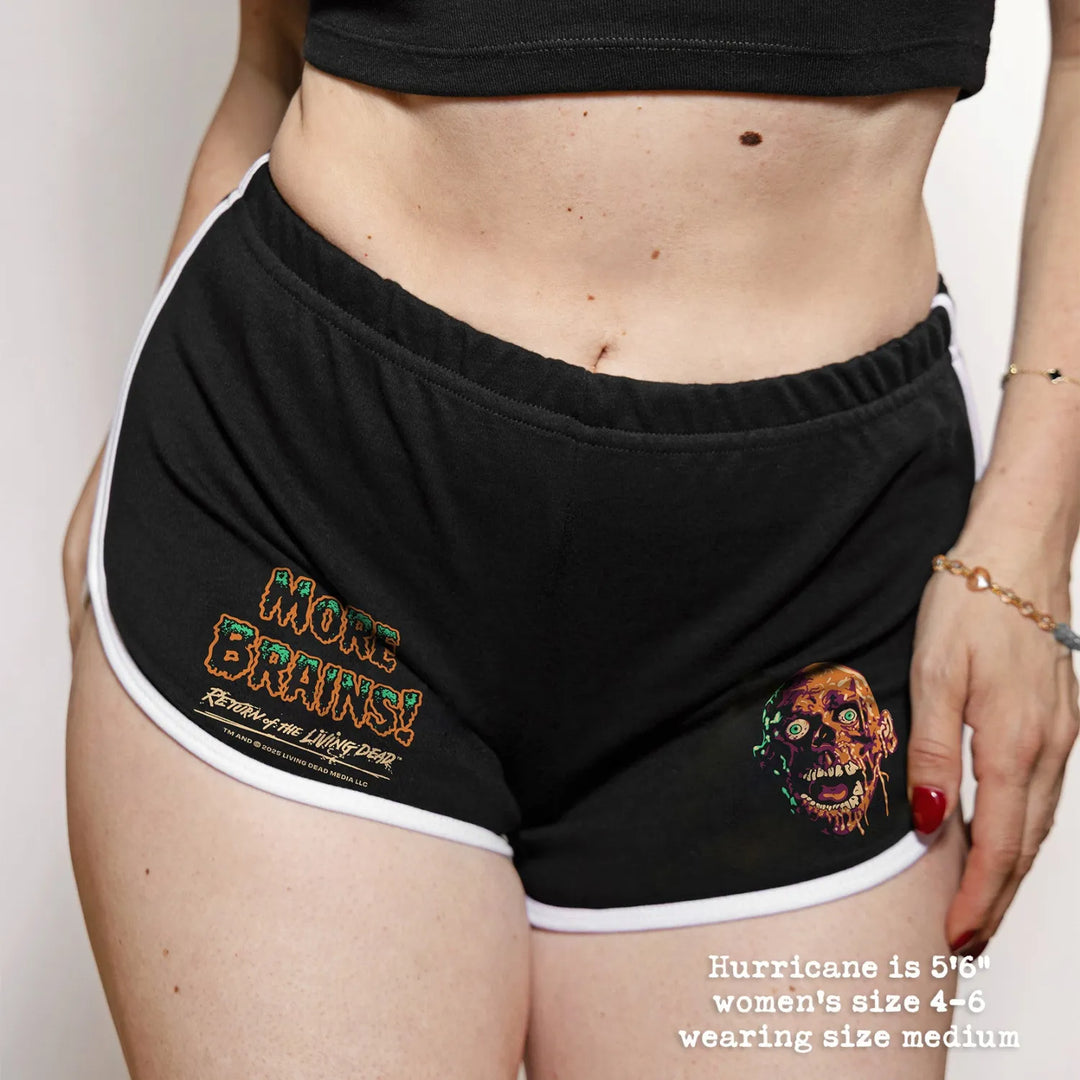 Black athletic shorts with elastic waistband and white trim featuring a zombie graphic and more brains text retro sport style