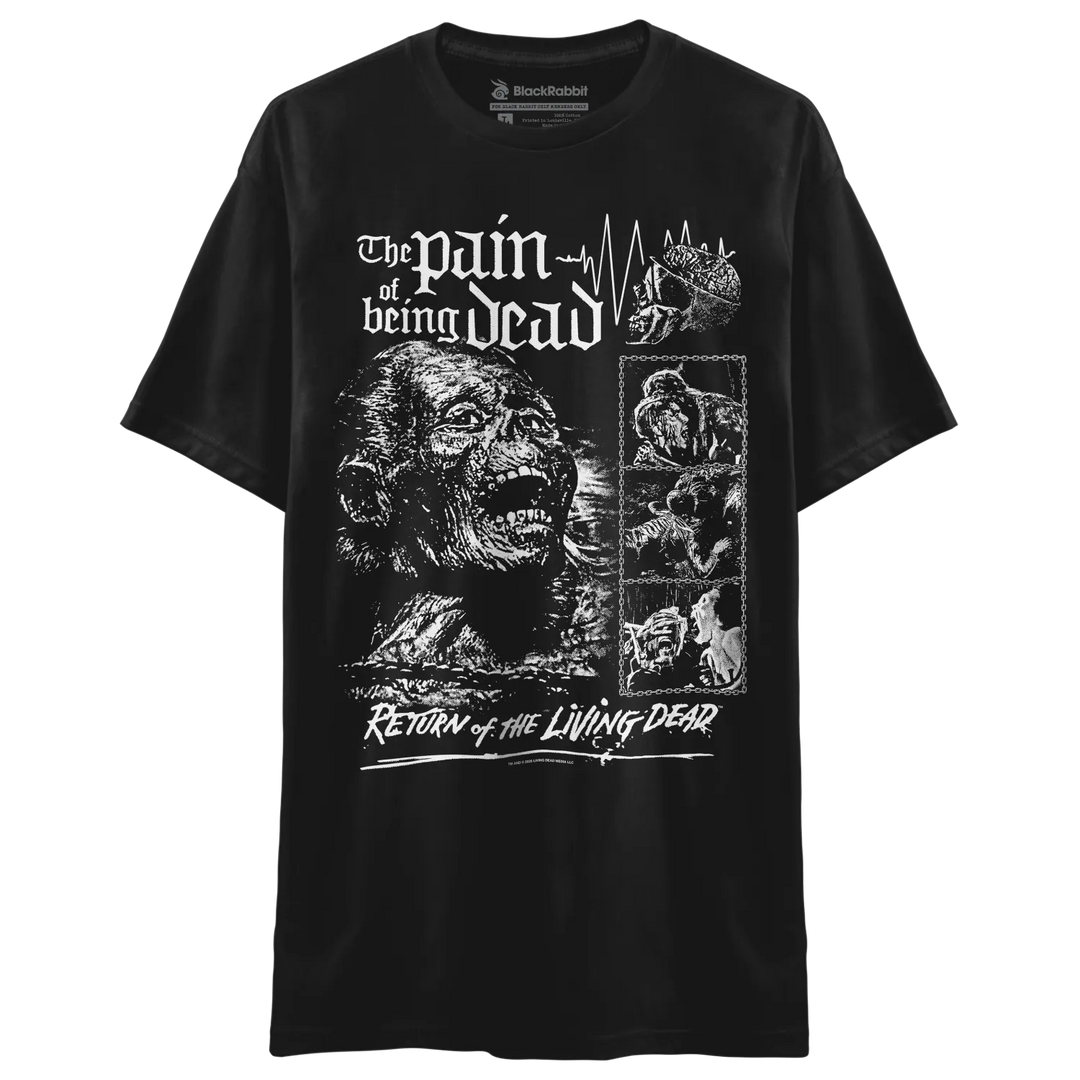 A black short-sleeve graphic t-shirt featuring white horror-themed artwork and text reading 'The pain of being dead' and 'Return of the Living Dead,' with a zombie illustration and smaller comic-style panels.