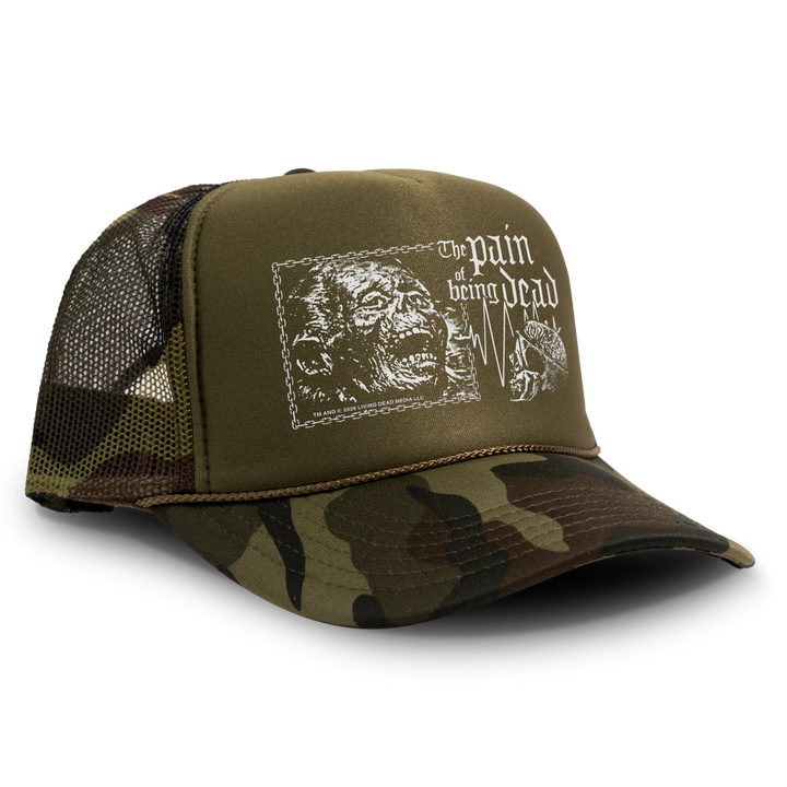 Olive green and camouflage living dead trucker hat with white zombie graphic and the pain of being dead text, officially licensed