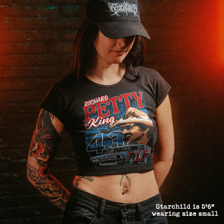 Female model wearing cropped baby tee with richard petty graphic
