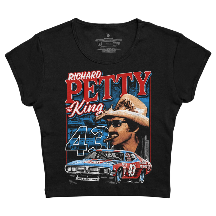 Black short-sleeved t-shirt featuring a vibrant graphic of richard petty, ’the king,’ in his iconic cowboy hat and sunglasses with the number 43 prominently displayed above his race car.