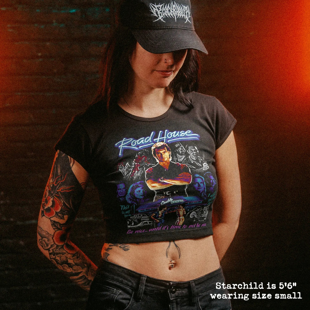 Female model wearing cropped baby tee with road house graphic
