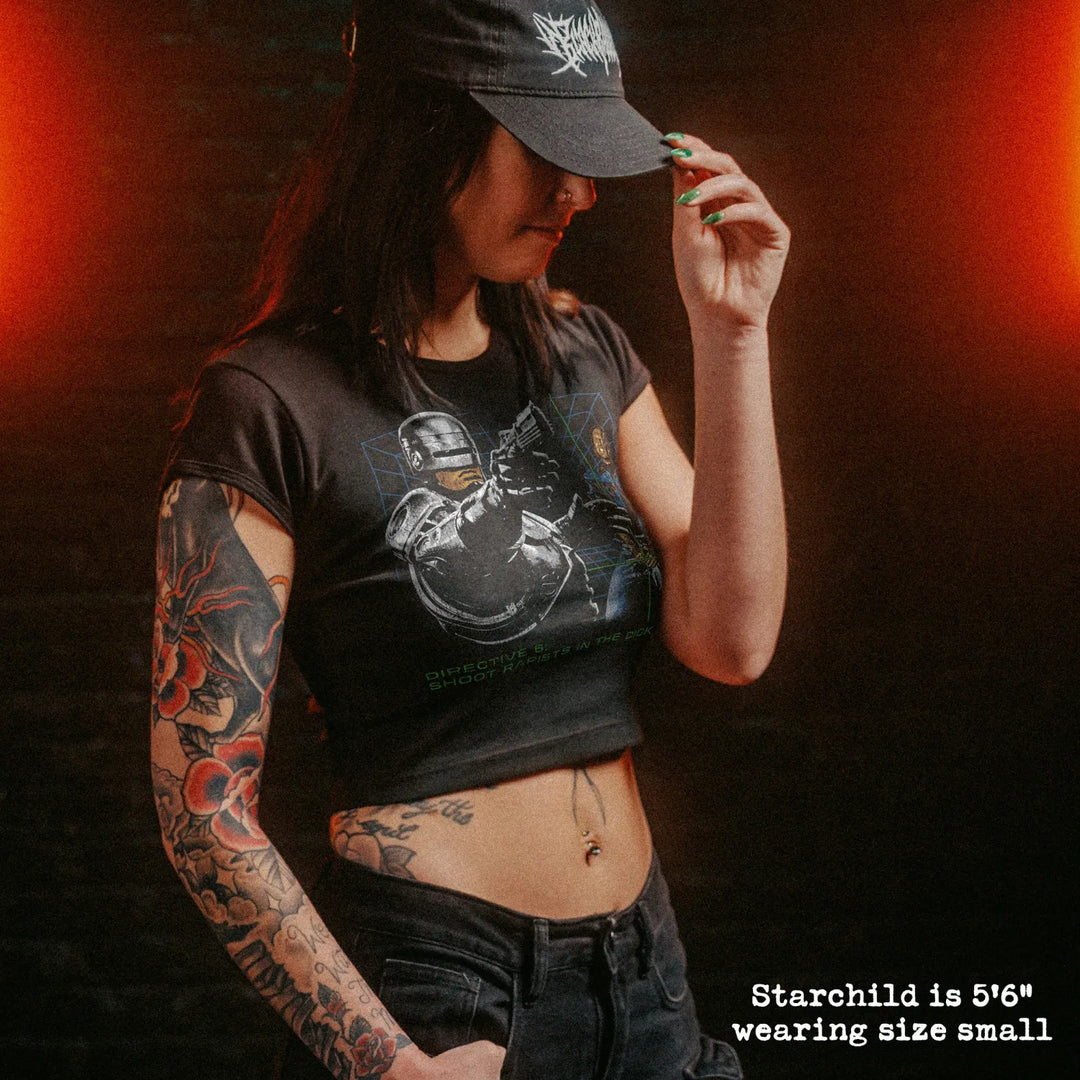 Female model wearing cropped baby tee with robocop dick shot graphic
