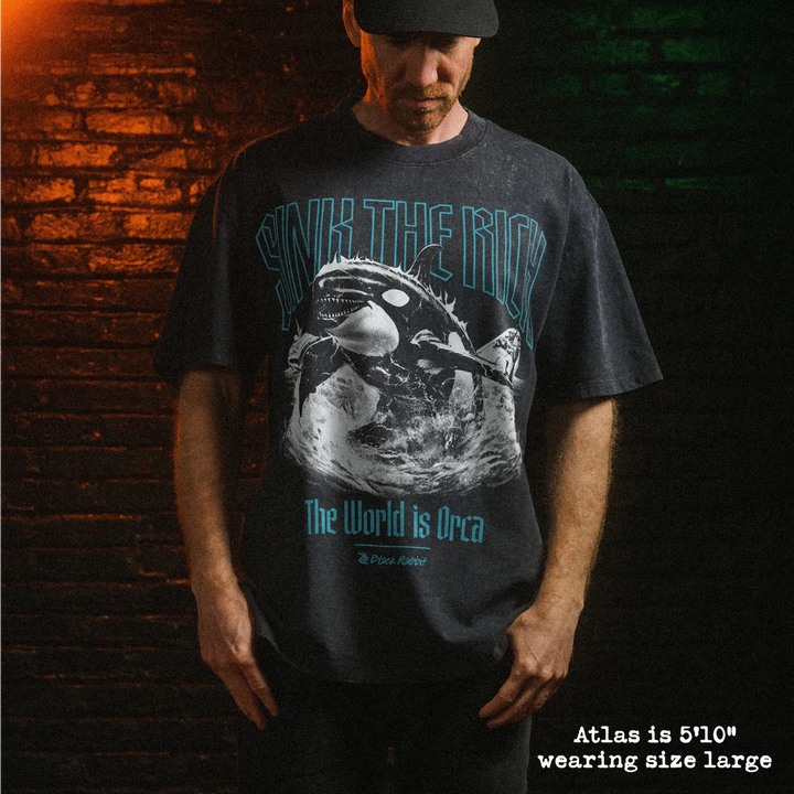 Male model wearing heavy stone washed tee with orca graphic. 