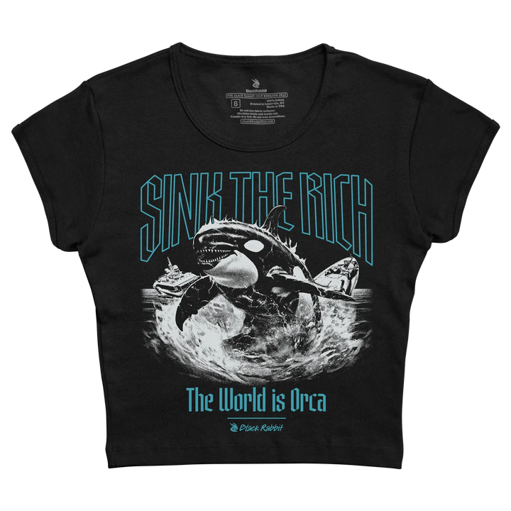 Black short-sleeved crop top featuring a bold graphic of an orca with the text ’sink the rich’ in teal outlined letters above and ’the world is orca’ below, designed by black rabbit.