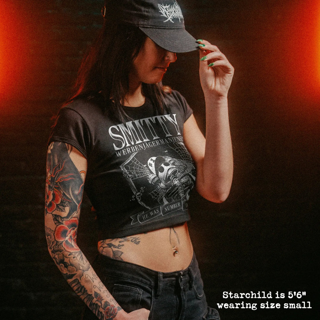 Female model wearing cropped baby tee with smitty graphic
