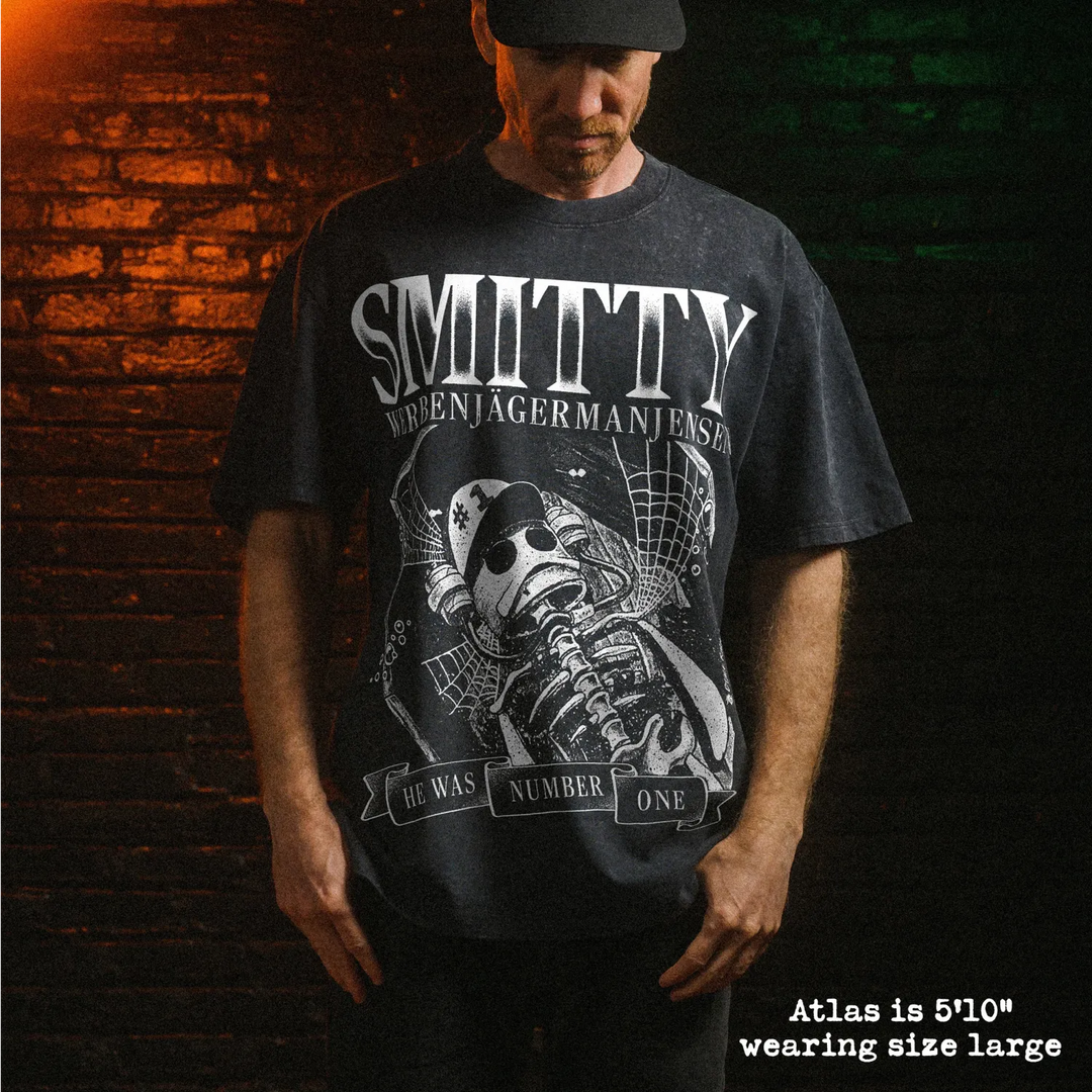 Male model wearing heavy stone washed tee with smitty graphic. 