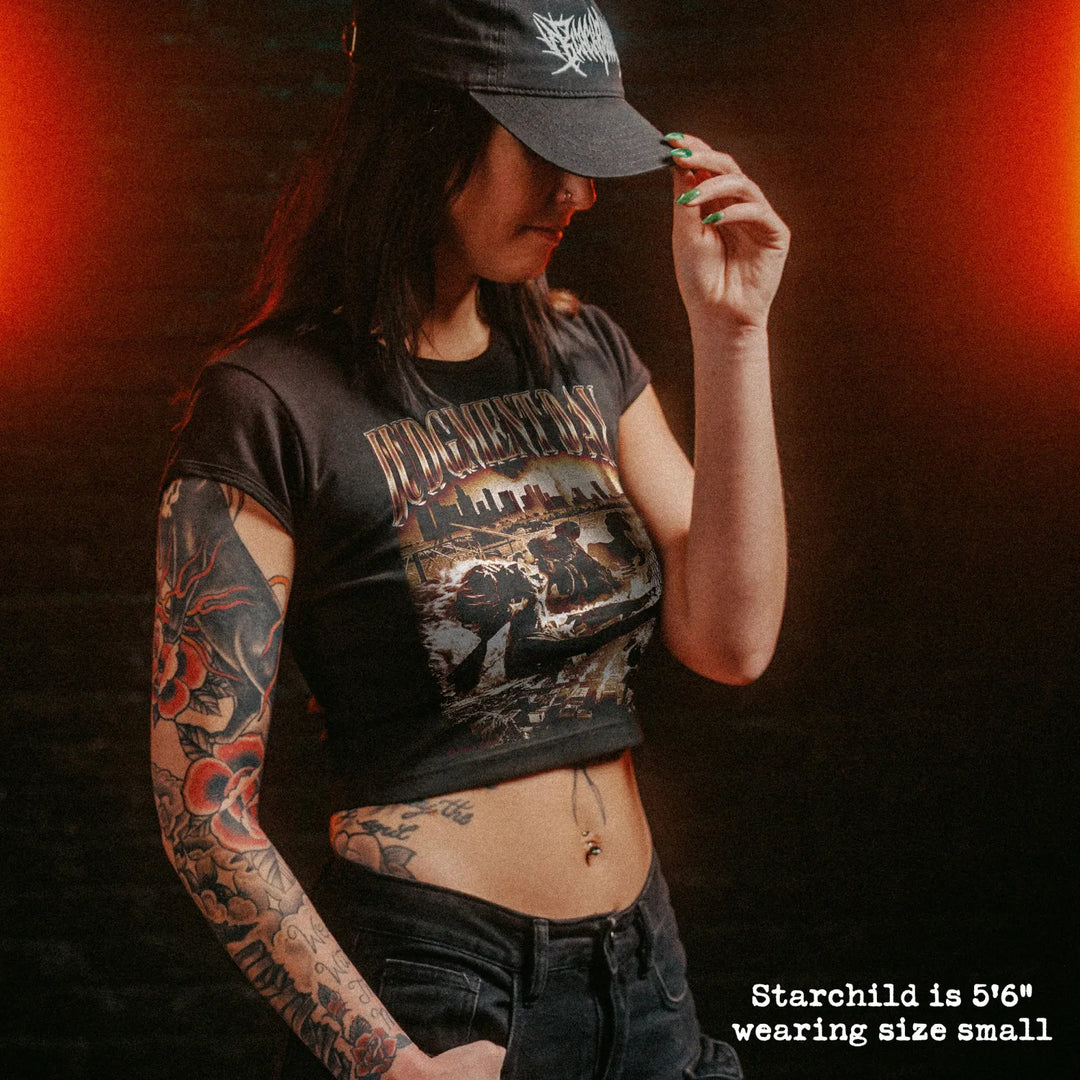 Female model wearing cropped baby tee with judgment day graphic
