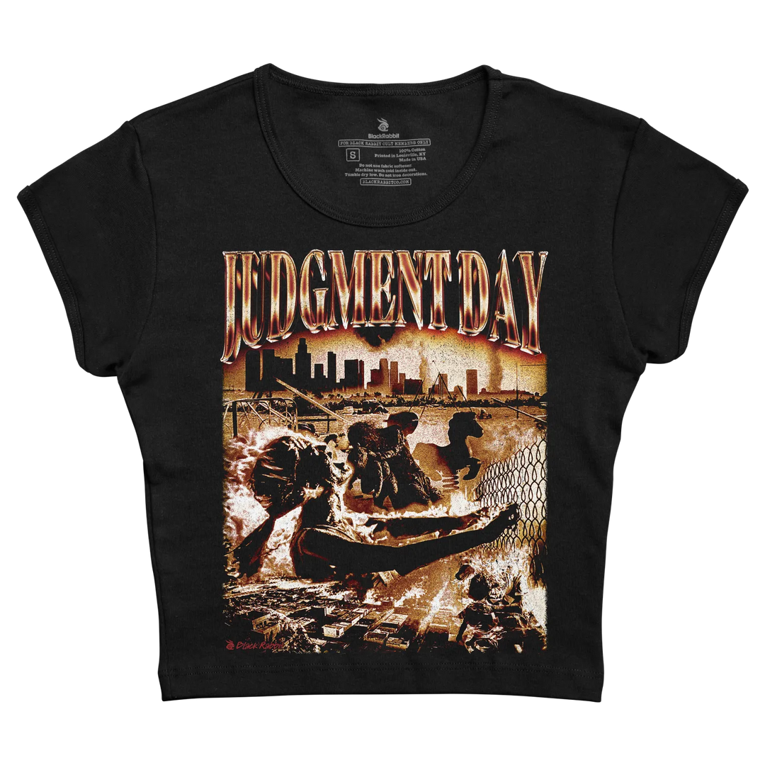 Black short-sleeved t-shirt featuring a fiery ’judgment day’ graphic with an apocalyptic cityscape and figures in motion, printed on cotton fabric.