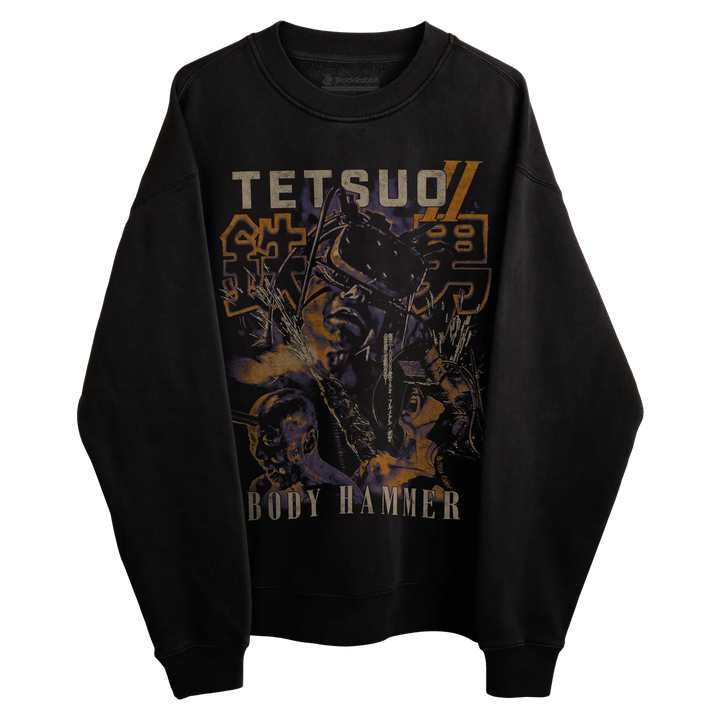 Black crewneck sweatshirt featuring a graphic print of the anime character tetsuo from ’tetsu no ki’ with bold yellow and purple lettering. 
