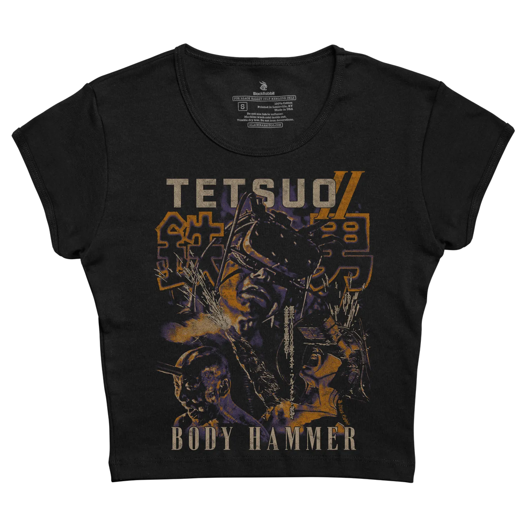 Black short-sleeved t-shirt featuring a graphic print of the anime character ’tetsuo’ with bold orange and purple lettering, designed by blackhood. 