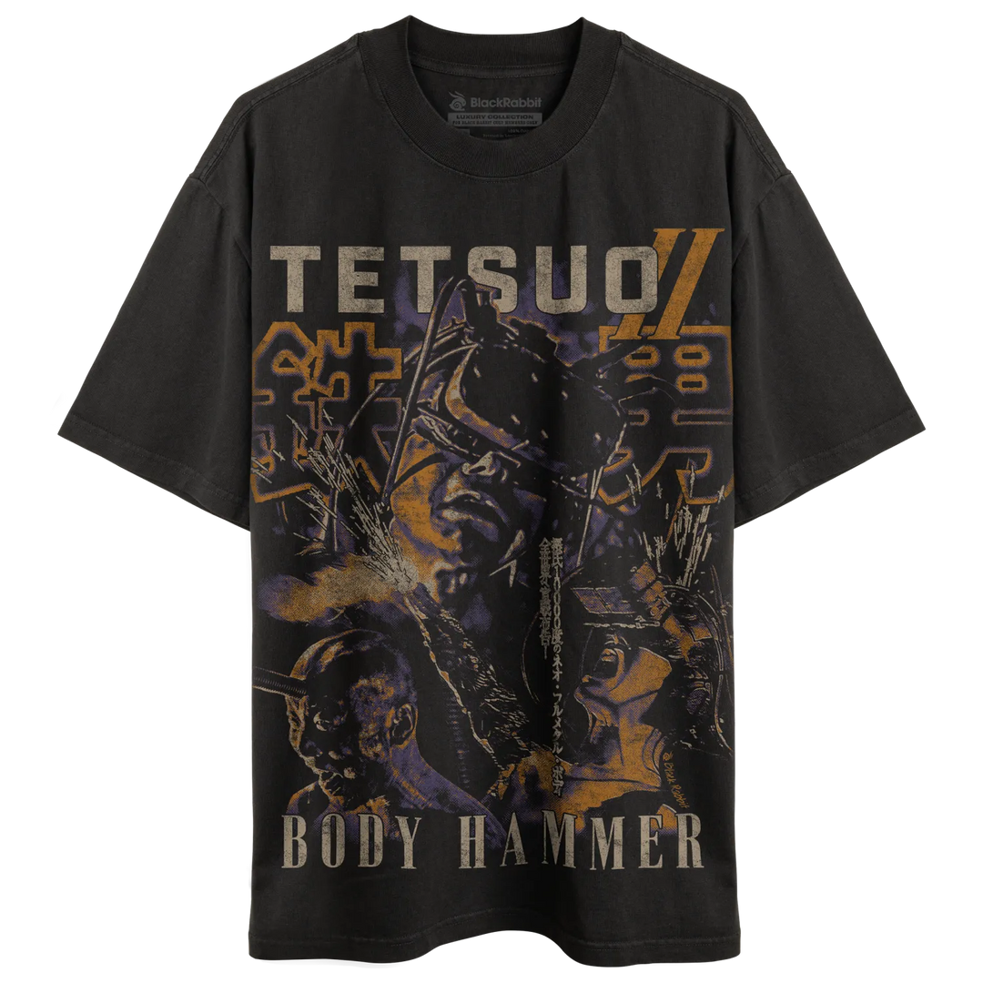 Black distressed t-shirt featuring a graphic of the character tetsumi ’tetsuo’ from body hammer with bold yellow and orange lettering. 